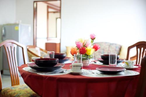 曼谷蓬乔克公馆酒店的桌子上放有盘子和杯子,花朵