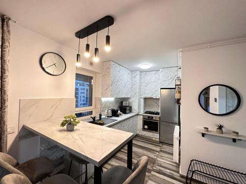 布拉索夫Deluxe Cozy Apartments - Coresi Mall的厨房配有桌子和墙上的时钟