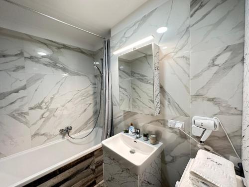 布拉索夫Deluxe Cozy Apartments - Coresi Mall #Brasov的白色的浴室设有水槽和淋浴。