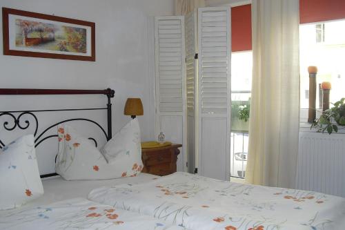 爱尔福特罗伊斯膳食公寓 - 加尼酒店的一间卧室配有一张带白色床单的床和一扇窗户。