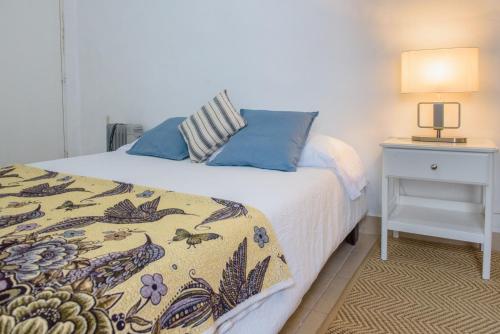 墨西哥城Charming House at Roma的一间卧室配有一张床和一张带台灯的桌子