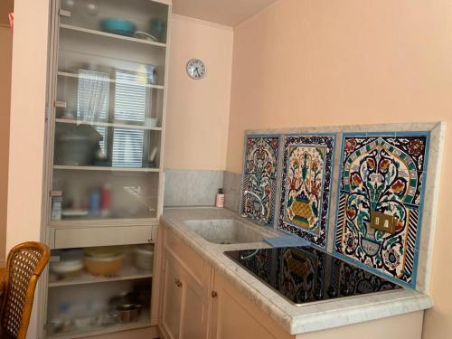维亚雷焦loft flavia的厨房设有水槽,墙上铺有马赛克瓷砖。