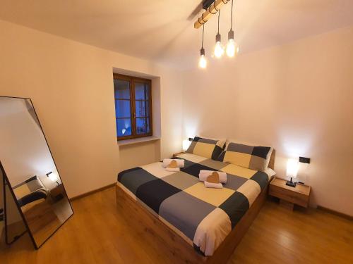 普雷达佐ElvesHome - Alpine Stay Apartments的卧室配有带枕头的大床和窗户。