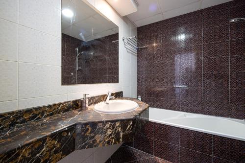 迪拜Luxury and spacious full Marina view的一间带水槽、浴缸和镜子的浴室