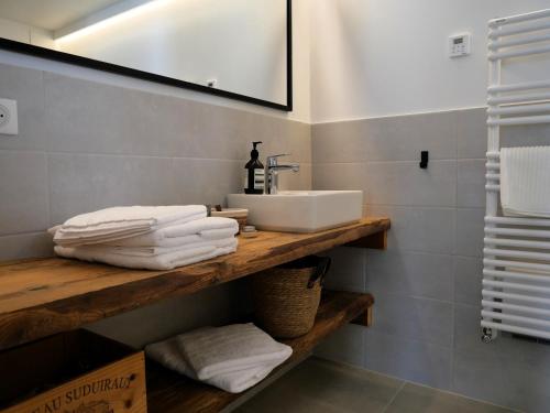 欧特吕斯La ferme d'Hauteluce - Chambre d'hôtes的木制架子上配有水槽和毛巾的浴室