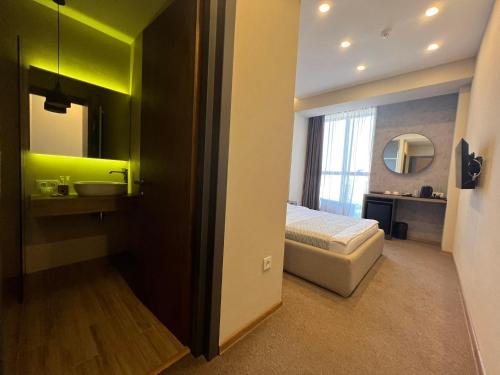 第比利斯Hotel Sky Station的一间卧室配有床、水槽和镜子