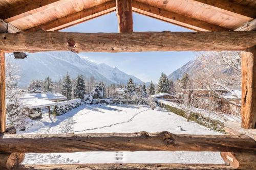 夏蒙尼-勃朗峰Spectacular Chalet with 5 ensuite bedrooms and sauna的从小木屋的窗户欣赏雪覆盖的院子的景色