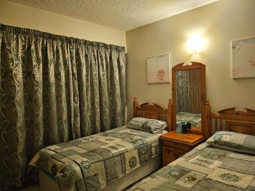 阿曼济姆托蒂Stella Maris 118的一间卧室设有两张单人床和一面镜子