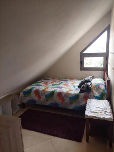 伊夫兰Apartement Charmante a Ifrane的一张带五颜六色的被子的床