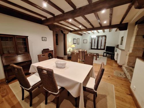 桑提亚纳德玛APARTAMENTOS PALACION DE SANTILLANA的一间配备有白色桌椅的用餐室
