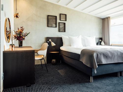 托尔斯港佛洛雅酒店的一间卧室配有一张床、一张桌子和一把椅子