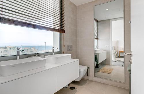 卡亚俄萨尔瓦赫Villa Izabele Orange的一间带两个盥洗盆、卫生间和窗户的浴室