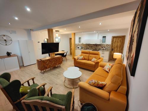 桑坦德Apartamentos Santander 2的一间带橙色沙发的客厅和一间厨房