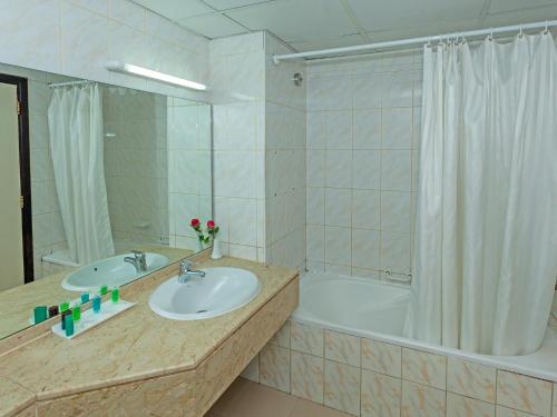迪拜Wave International Hotel的带浴缸、水槽和淋浴的浴室