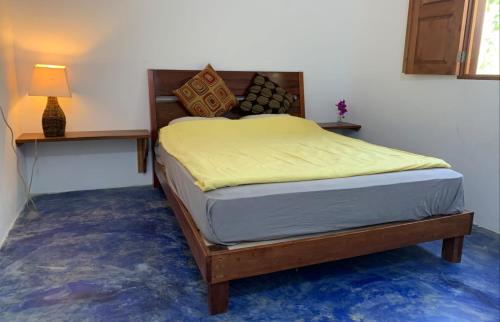 弗洛勒斯Casa Alemán的一间卧室配有一张带黄床单和一盏灯的床。