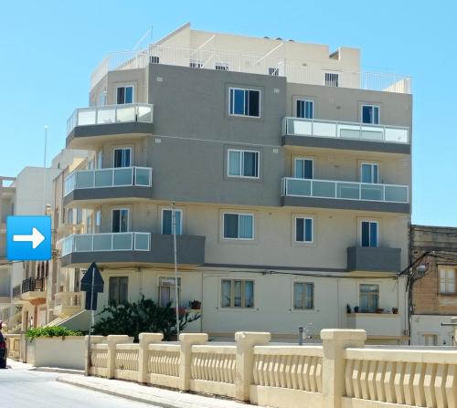 Siġġiewi"Joseph 2" Stylish corner flat with open views, just 5km from the beach的前面有栅栏的高楼