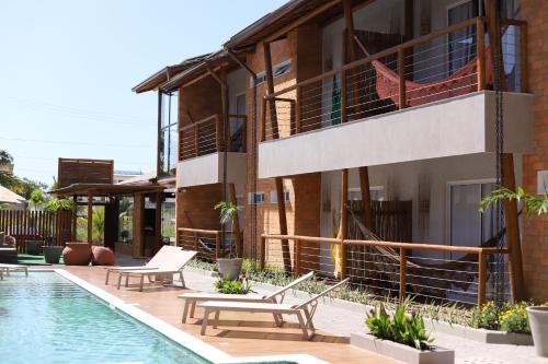 马拉戈日Uri Pousada的一个带游泳池和椅子的度假胜地和一座建筑