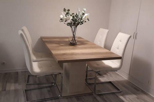 埃勒凡达尔Apartamento acogedor的一张桌子、白色的椅子和花瓶