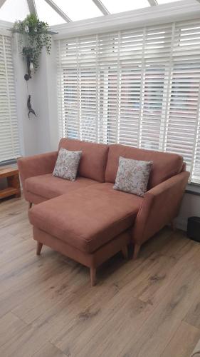 SuttonEllesmere port的客厅设有一张棕色沙发,配有窗户