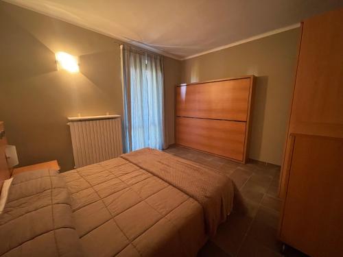 弗拉博萨索普拉纳Appartamento in centro Paese的一间卧室配有一张带木制床头板的床