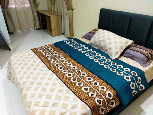 瓜拉丁加奴Sya Al-Yahya Homestay的床上有蓝色和白色的毯子