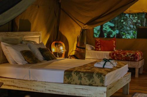 别霍港Colina Secreta - Glamping and Villas的一间卧室配有一张床和一个帐篷