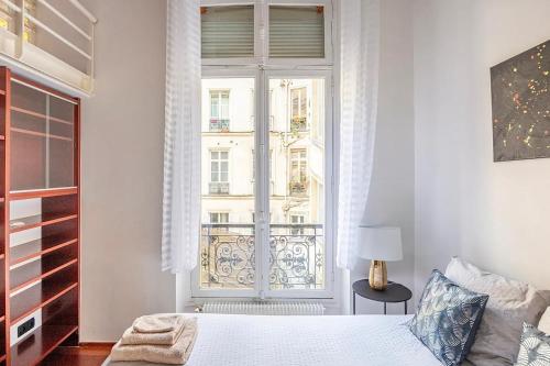 巴黎Chic Parisian Flat的一间卧室设有一张床和一个大窗户