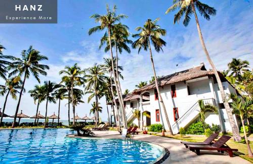Ấp Thiện SơnHANZ Sun Sea Glamping & Beach Resort的一个带游泳池和棕榈树的度假村