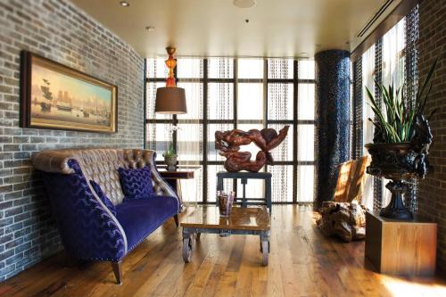 萨凡纳萨凡纳河波西米亚酒店 - 澳头格拉芙集团的客厅配有蓝色的沙发和桌子
