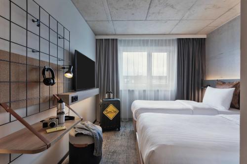 汉堡Moxy Hamburg Altona的酒店客房设有两张床和窗户。