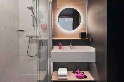 汉堡Moxy Hamburg Altona的浴室配有盥洗盆和带镜子的淋浴