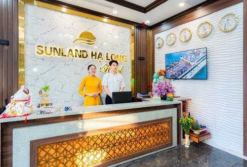 下龙湾Sunland Halong Hotel and Restaurant的大堂设有大壁炉和墙上的海报