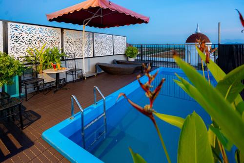 下龙湾Sunland Halong Hotel and Restaurant的阳台的游泳池,带雨伞