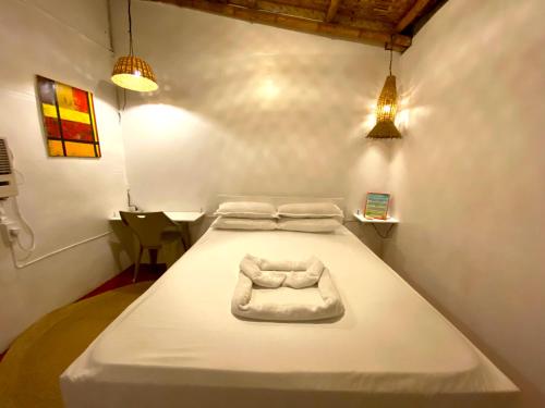 TibiaoKasa Raya Inn的配有两盏灯的房间的一张白色床