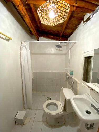 TibiaoKasa Raya Inn的浴室配有白色卫生间和盥洗盆。