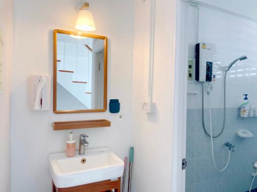 大城Room Story Hostel的一间带水槽、镜子和淋浴的浴室
