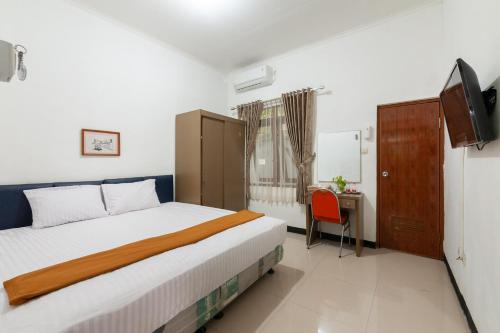 BantarkamangHouse of M Bogor Mitra RedDoorz的一间卧室配有一张床、一张书桌和一台电视