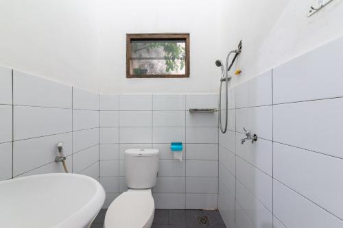 BantarkamangHouse of M Bogor Mitra RedDoorz的白色的浴室设有卫生间和窗户。