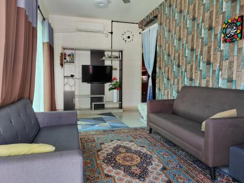Kampong JemamparTeratak Delisha -musslim的客厅配有两张沙发和一台电视机