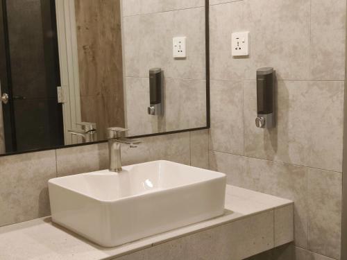 乔治市ZOOM HOTEL的浴室设有白色水槽和镜子