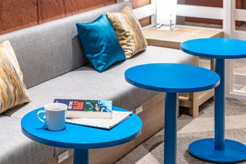 神户the b kobe的客厅设有两张蓝色的桌子和一张沙发