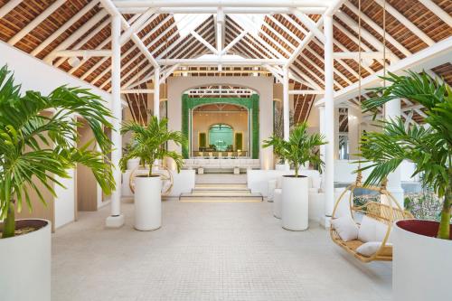贝尔马尔LUX* Belle Mare Resort & Villas的楼内种有棕榈树的走廊