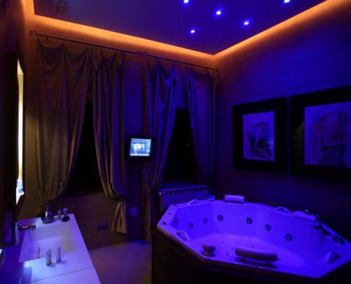 巴列斯特罗卡拉特拉瓦帕拉西奥德拉塞尔纳精品酒店的紫色浴室设有浴缸和两个水槽