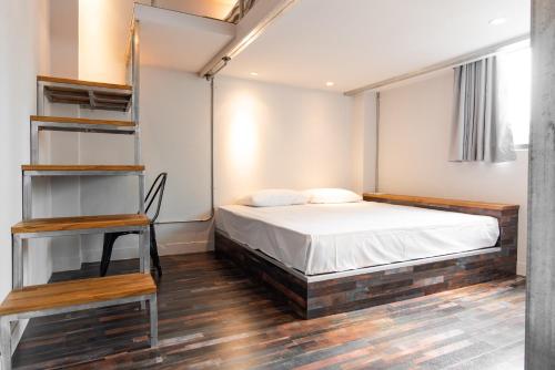 台北米尼旅店的一间卧室配有床和书架