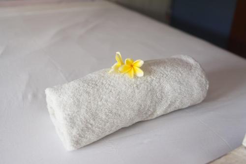 蓝梦岛Castaway Island Hostel的床上的白色毛巾,黄色的花