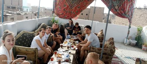 卢克索Grand Hotel &Hostel的一群人坐在屋顶的桌子旁