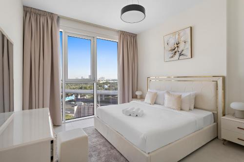 迪拜Spacious 1BR APT Wasl的卧室配有白色的床和大窗户