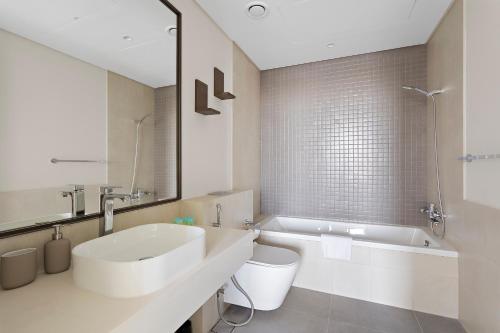 迪拜Spacious 1BR APT Wasl的白色的浴室设有水槽和浴缸。