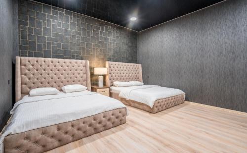 第比利斯Urban Villa By Umbrella的一间带两张床的卧室和瓷砖墙