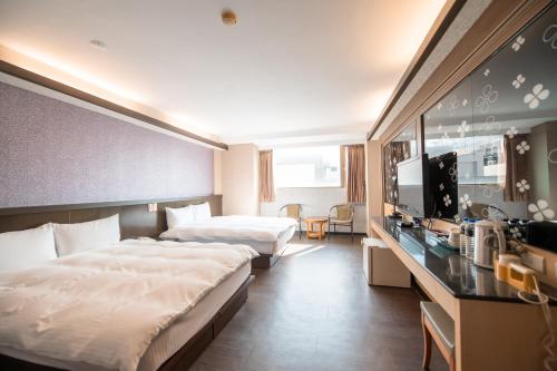台中市台中灣文旅 T C ONE Hotel的酒店客房设有两张床和电视。
